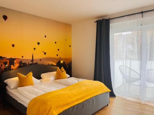 ein Schlafzimmer mit einem Bett mit gelber Bettwäsche und einem Fenster in der Unterkunft APSTAY Serviced Apartments - Self Check-in in Graz