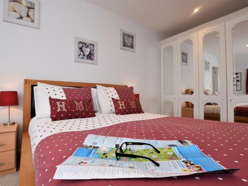 um quarto com uma cama com uma colcha vermelha e branca em 1 Bed in Lyme Regis 62615 em Axminster