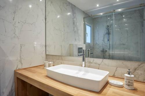 a bathroom with a large white sink and a shower at GLAMOROUS APARTMENT IN KOLONAKI CENTER in Athens