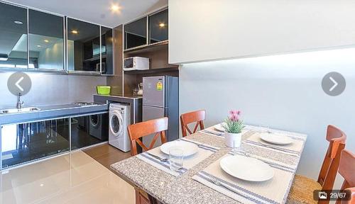 a kitchen with a table and chairs in a kitchen at Lasalle Park Serviced Apartment at Lasalle 75 in Bangna