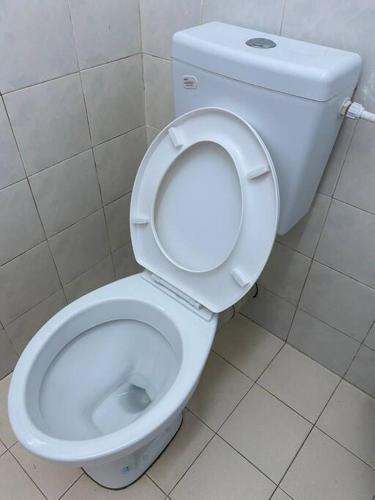 a bathroom with a white toilet with the seat up at Go Holiday Taiping Homestay in Simpang