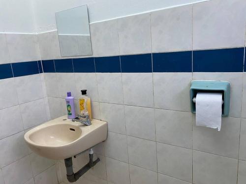 a bathroom with a sink and a toilet paper dispenser at Go Holiday Taiping Homestay in Simpang