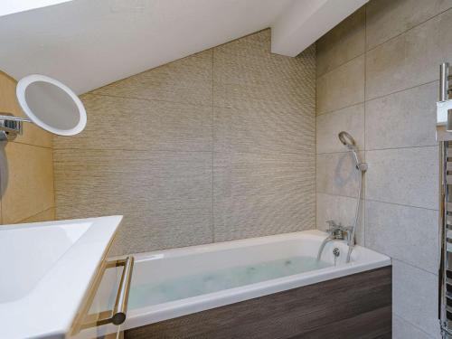 a bathroom with a tub and a shower at 3 Bed in Cartmel 66725 in Holker