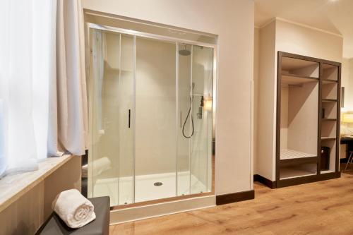 baño con ducha y puerta de cristal en Hotel Leonardo da Vinci en Florencia