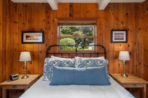 una camera da letto con un letto con pareti in legno e una finestra di The Pilot House by AvantStay Stunning Home Right On Arch Cape Beach ad Arch Cape