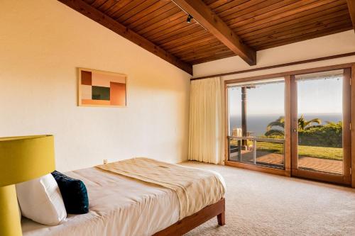 a bedroom with a bed and a large window at Cliffridge by AvantStay Lush Malibu Hills Estate w Breathtaking Ocean Views in Malibu