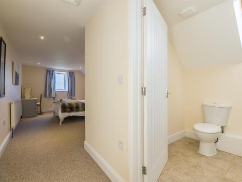 a bathroom with a toilet and a bedroom at 2 bed in Pensthorpe KT188 in Kettlestone