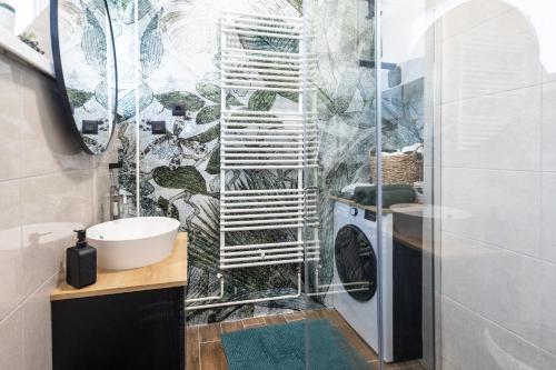 a bathroom with a washing machine in a shower at New Green Studio Apartment near Tvrđa in Osijek