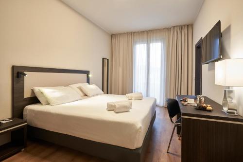 ein Hotelzimmer mit einem großen Bett und einem Schreibtisch in der Unterkunft Hotel Leonardo da Vinci in Florenz