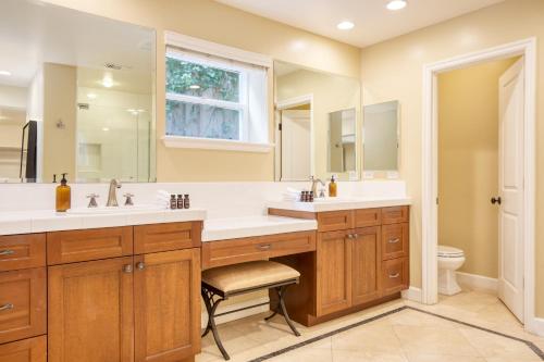 a bathroom with two sinks and a large mirror at Wavebreak by AvantStay Close to BeachesSurfing in Solana Beach