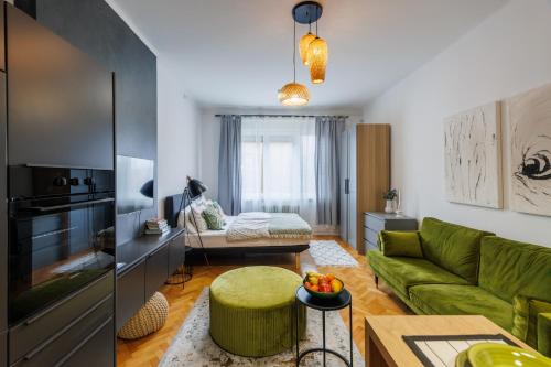 a living room with a green couch and a table at New Green Studio Apartment near Tvrđa in Osijek
