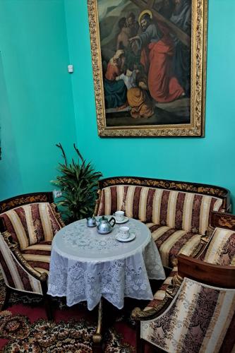 a living room with a table and a painting at Вілла Графа in Lviv