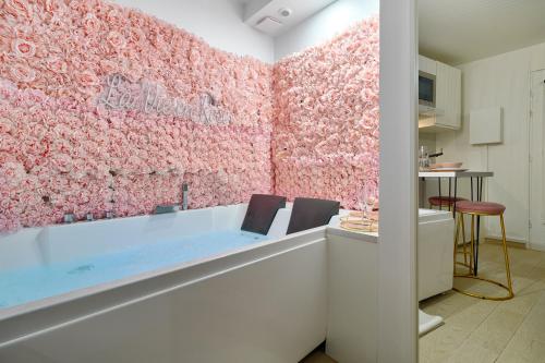 ein Badezimmer mit einer rosa Wand und einer Badewanne in der Unterkunft La Vie en Rose / Jacuzzi in Montgeron