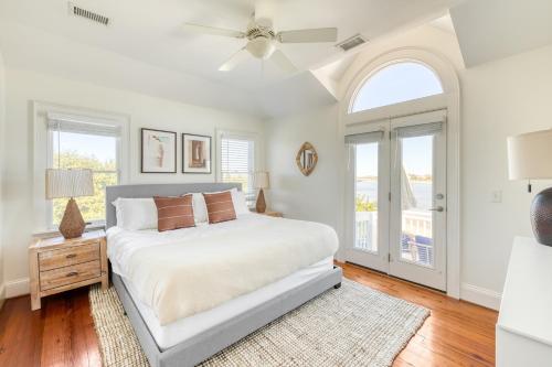 1 dormitorio blanco con 1 cama y ventilador de techo en Haven by AvantStay Luxury Beachfront Home w Pool Gorgeous Patios en Sullivans Island