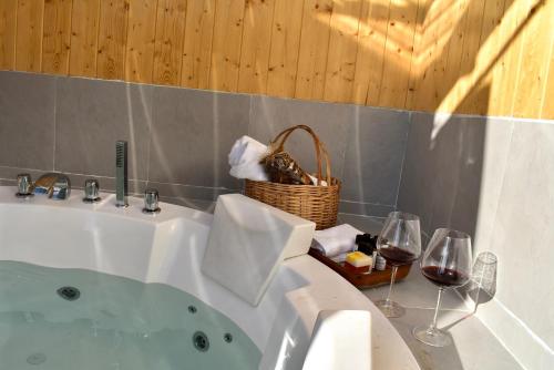 eine Badewanne mit einem Korb mit Handtüchern und Weingläsern in der Unterkunft Mahantam Luxury Stays in Nagar