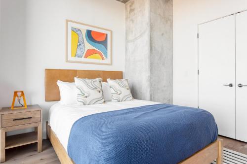 a bedroom with a bed with a blue blanket at Vice by AvantStay Brand New Condo Room in Austin w Amazing Amenities in Austin