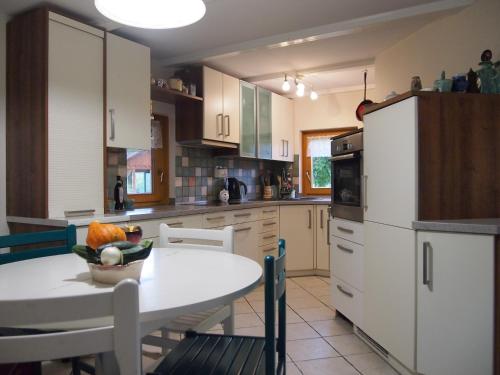 a kitchen with a table with a bowl of fruit on it at Guest House Bitter in Braslovče