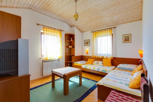 ein Wohnzimmer mit einem Sofa und einem TV in der Unterkunft Filip Apartment in Mali Lošinj