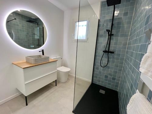 une salle de bain avec un lavabo et une douche avec un miroir dans l'établissement Maison avec piscine et jardin privatifs - un séjour au calme, à Biscarrosse