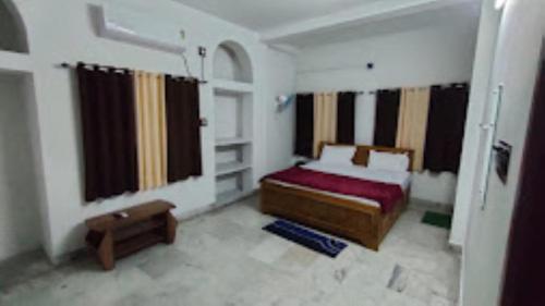 - une chambre avec un lit et une fenêtre avec des rideaux dans l'établissement Hotel The Aparna Residency, Lodge and Restuarant , Asansol, à Āsansol