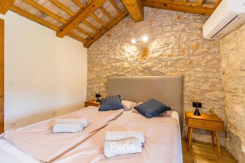 ein Schlafzimmer mit einem großen Bett in einer Steinmauer in der Unterkunft Charming stone Villa CX with large 50m2 heated pool in Brtonigla