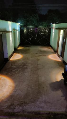 un parking vide avec un portail la nuit dans l'établissement Hotel The Aparna Residency, Lodge and Restuarant , Asansol, à Āsansol
