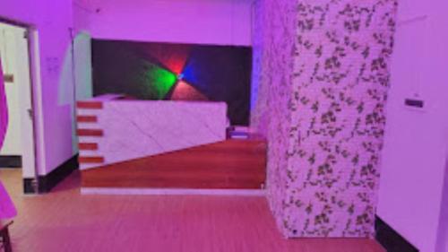 a purple room with a bed and a table at Hotel The Aparna Residency, Lodge and Restuarant , Asansol in Āsansol