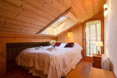 una camera con un grande letto in una casa di legno di Chalets d'en haut - Bonheur - Happy Rentals a Chamonix-Mont-Blanc