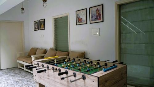 a living room with a large wooden foosball table at Stay Banaras - A Boutique Hotel in Varanasi