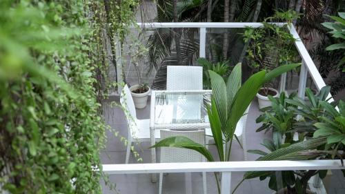 a balcony with a white chair and plants at Stay Banaras - A Boutique Hotel in Varanasi