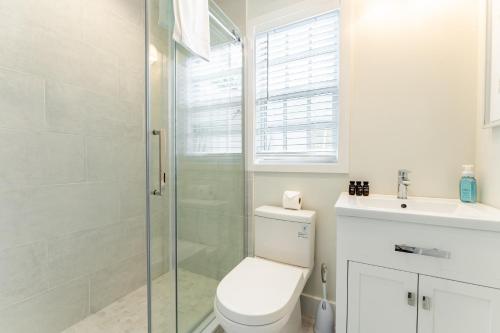 a bathroom with a toilet and a glass shower at Paradise Point by AvantStay Golf Course Living in Stock Island