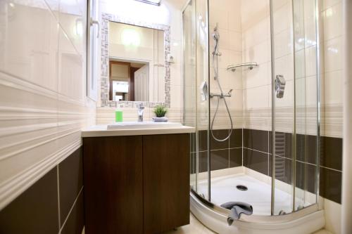 een badkamer met een douche, een wastafel en een bad bij Standard Apartment by Hi5 - Dessewffy 2 bedroom in Boedapest
