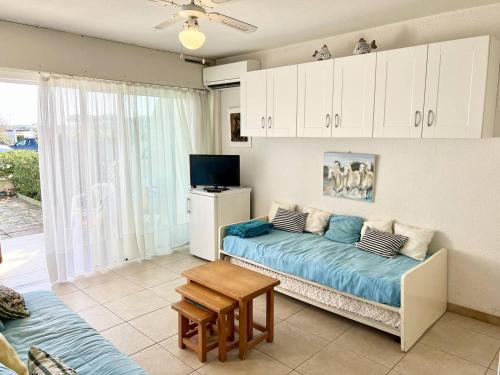 un salon avec un canapé et une table dans l'établissement STUDIO CLIMATISE 3 PERSONNES A PROXIMITE IMMEDIATE MER ET PLAGE, au Grau-du-Roi