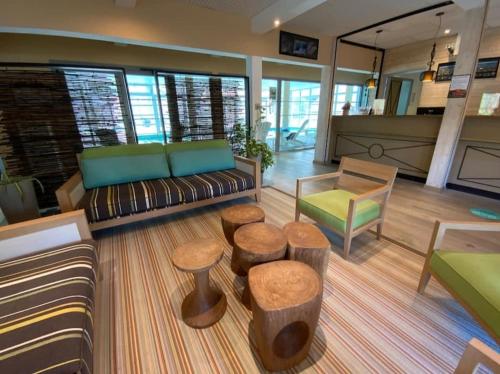 eine Lobby mit einem Sofa und Hockern in einem Zimmer in der Unterkunft Maison 6 personnes avec terrasse, piscines et sauna in Pornichet