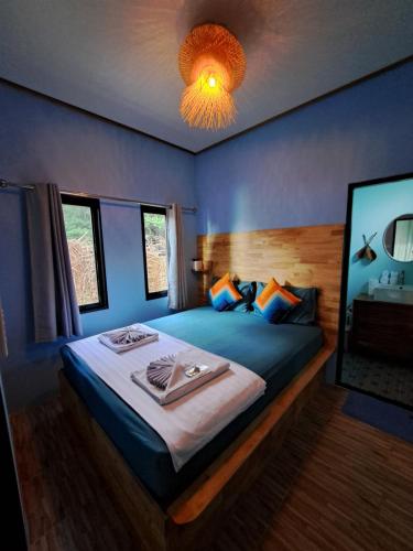 a bedroom with a large bed with blue walls at Sense Asia in Haad Tian