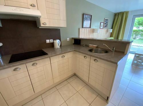 a kitchen with a sink and a counter top at Maison 6 personnes avec terrasse, piscines et sauna in Pornichet