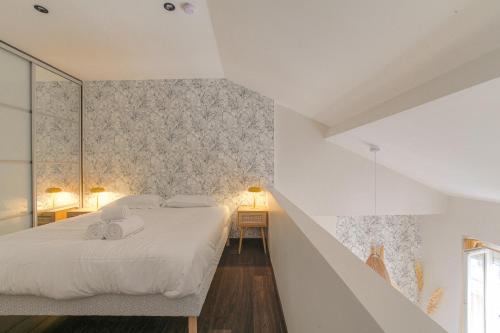 una camera bianca con un letto e una scala di Duplex spacieux et design proche la Part-Dieu a Lione