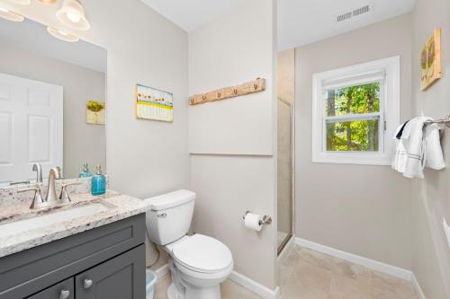 a white bathroom with a toilet and a shower at Cherry Blossom by AvantStay 6 Min to Downtown in Asheville