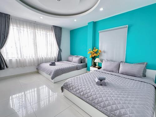 2 camas en una habitación con paredes azules en Thắng Hà Hotel, en Ho Chi Minh