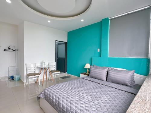 1 dormitorio con cama y pared azul en Thắng Hà Hotel, en Ho Chi Minh