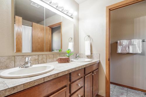 a bathroom with two sinks and a large mirror at Black Bear Cabin by AvantStay Modern Bend Escape in Bend