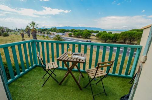 een tafel en stoelen op het balkon van een huis bij Studio et parking avec plage à 350m in Canet-en-Roussillon