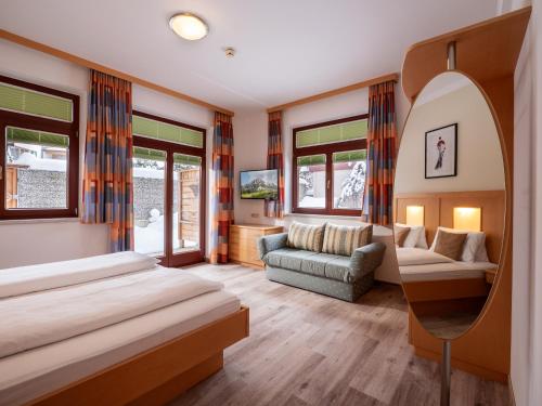 um quarto de hotel com uma cama e um espelho em Appartements Holiday em Ellmau