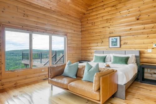 Dormitorio en cabaña de madera con cama y sofá en Chester by AvantStay Amazing Views Secluded Home A True City Escape, 