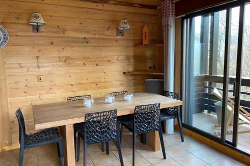a dining room with a wooden table and chairs at Apartment with balcony and panoramic view between sky and mountains in Megève