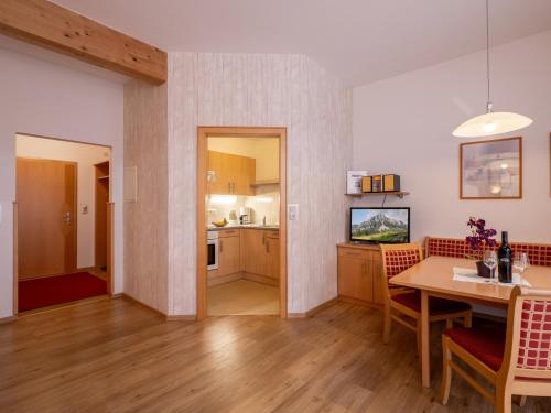 a kitchen and dining room with a table and chairs at Appartements Holiday in Ellmau