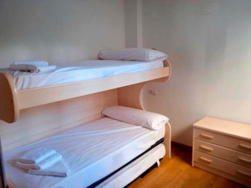 サジェント・デ・ガジェゴにあるApartamentos Sallent de Gállego 3000のドレッサー付きのドミトリールームの二段ベッド2台分です。