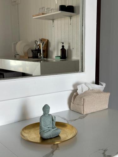 a buddha statue sitting on a table in a room at Beachfront house in Chaloklum in Mae Haad