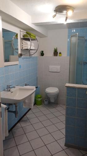 baño de azulejos azules con lavabo y aseo en Home Medau Spiga 