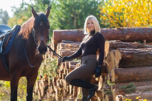 a woman is standing next to a horse at Pensjonat Iskra in Sztum